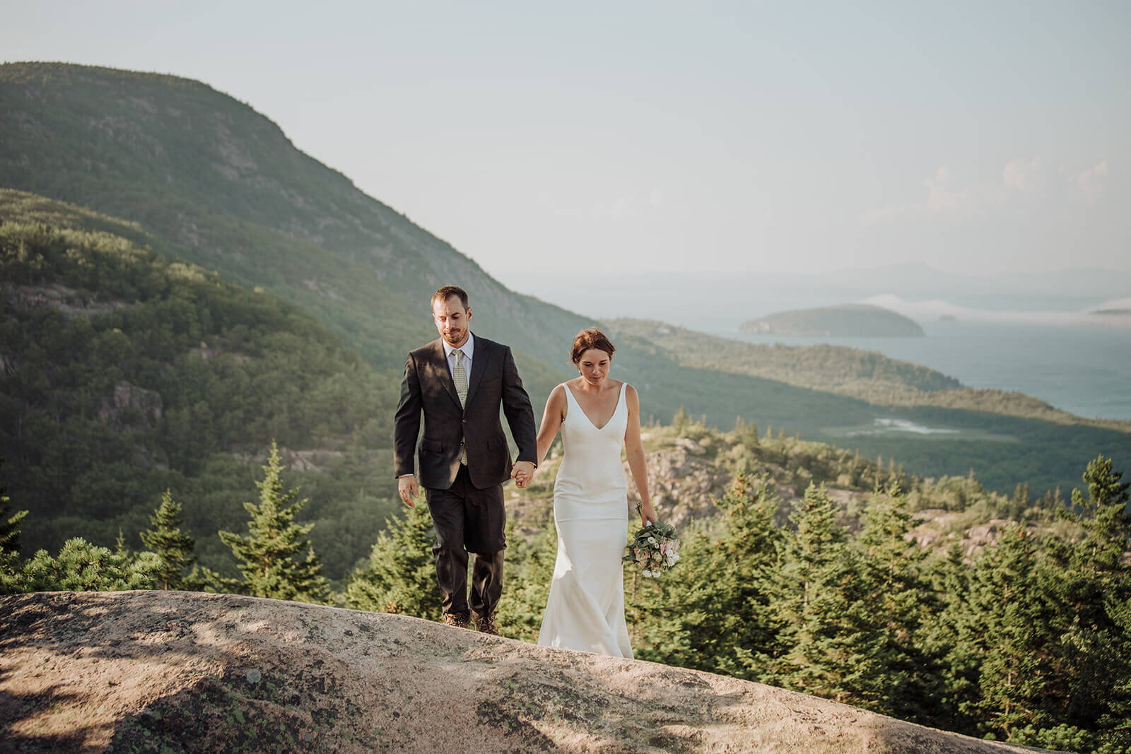  Couple takes in the views during their Acadia National Park elopement in Maine while hiking the Beehive. 