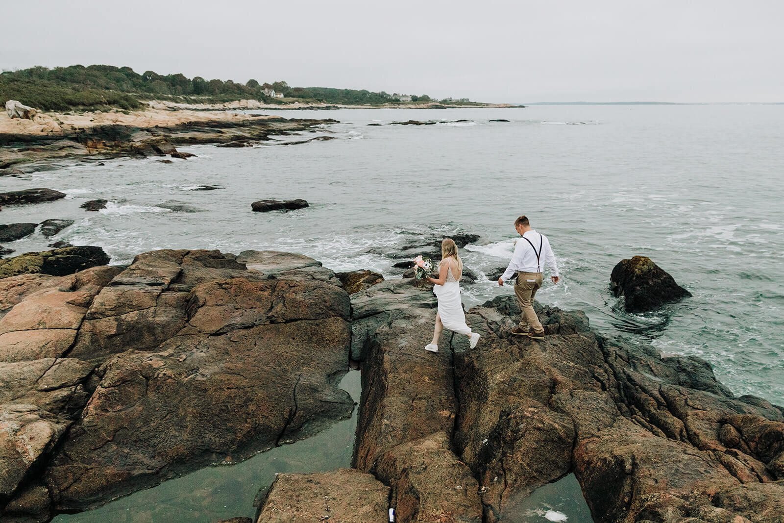  A couple explores during their elopement on the Rhode Island Coast in Narragansett.  