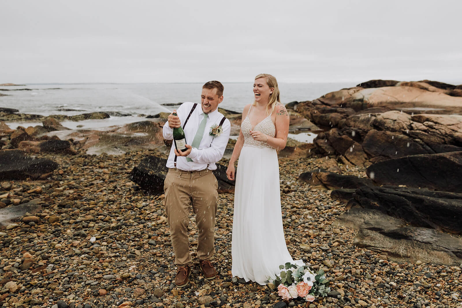  A couple celebrates with campagne during their elopement on the Rhode Island Coast in Narragansett. 
