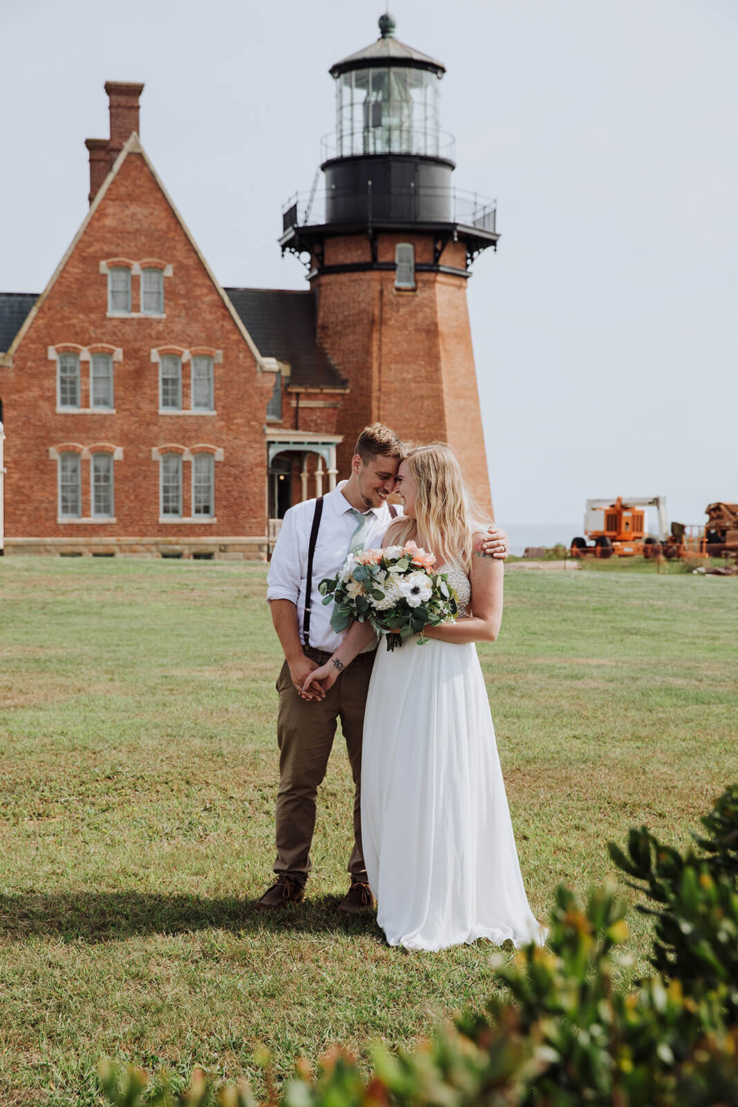  Couple at a lighthouse during their hiking and beach elopement on Block Island off the coast of Rhode Island. 