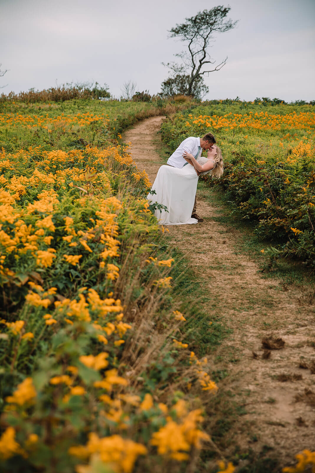  Eloping couple runs through flower fields during their hiking and beach elopement on Block Island off the coast of Rhode Island. 