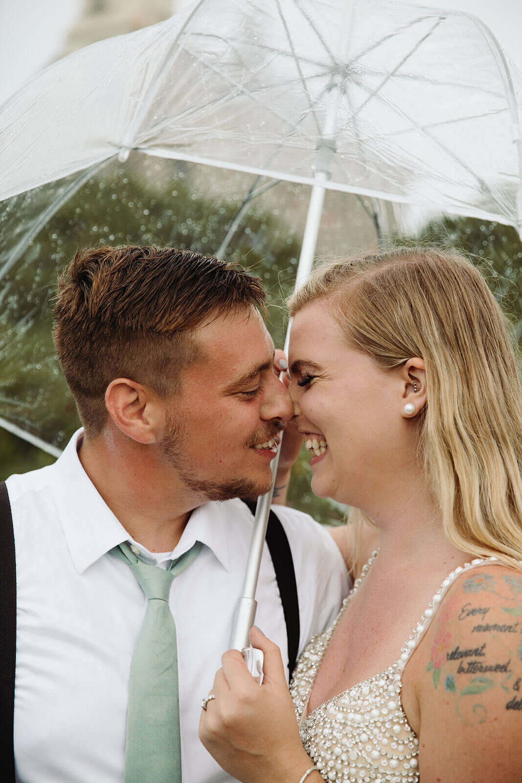  Eloping couple explores a lighthouse in the rain during their hiking and beach elopement on Block Island off the coast of Rhode Island. 