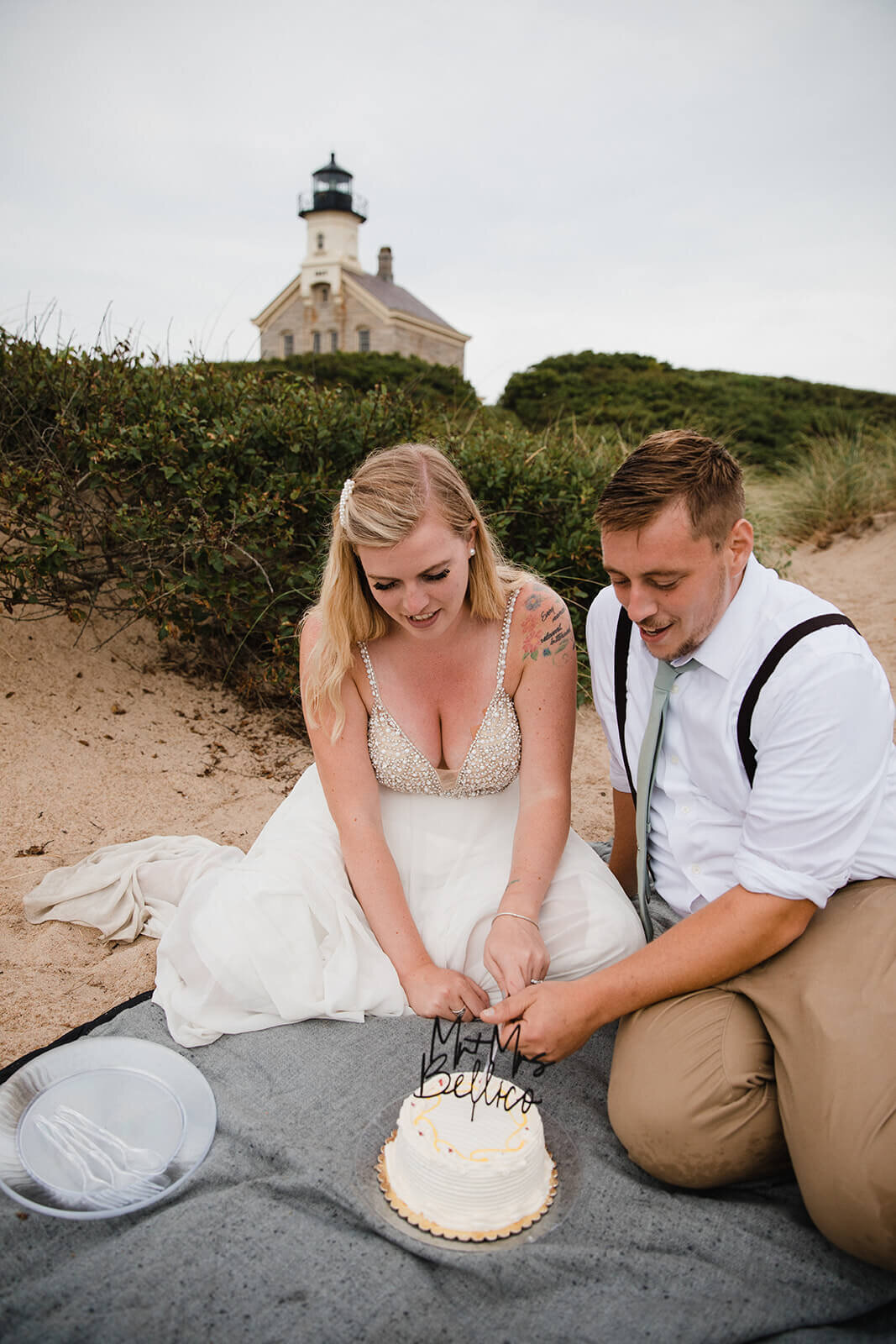  Eloping couple explores a lighthouse and cuts their cake during their hiking and beach elopement on Block Island off the coast of Rhode Island. 