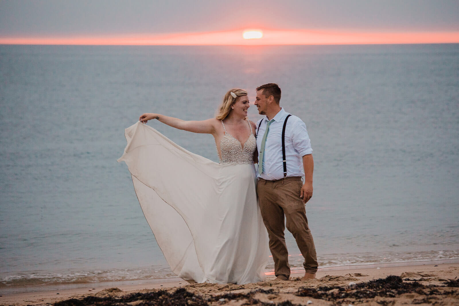  Eloping couple explores coastal views and sees a seal pop up during sunset as part of their hiking and beach elopement on Block Island off the coast of Rhode Island. 