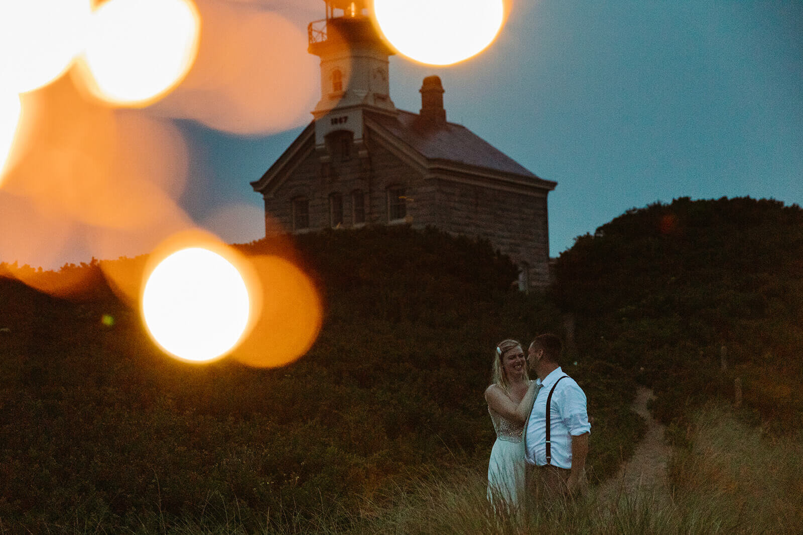  Eloping couple celebrates after dark as part of their hiking and beach elopement on Block Island off the coast of Rhode Island. 