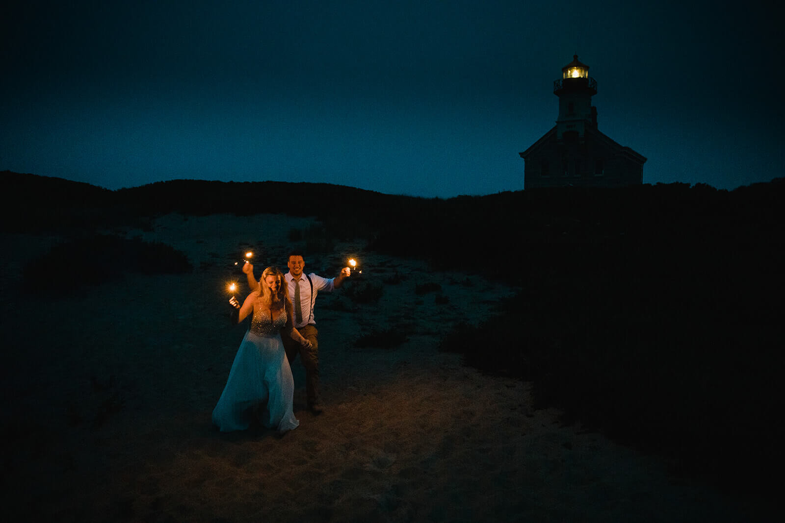  Eloping couple celebrates after dark as part of their hiking and beach elopement on Block Island off the coast of Rhode Island. 