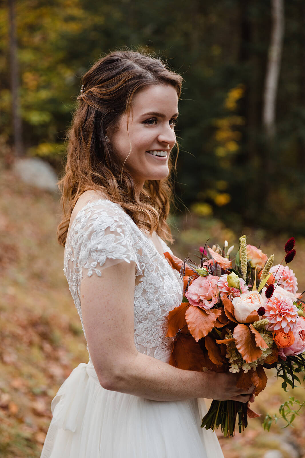  Bride holds bouquet during elopement in the White Mountains in New Hampshire. New Hampshire elopement packages. 