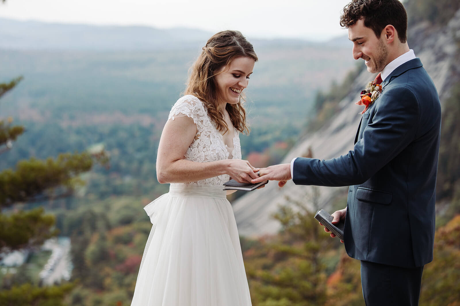  Bride and groom exchange rings during their ceremony during elopement in the White Mountains in New Hampshire. New Hampshire elopement packages. 