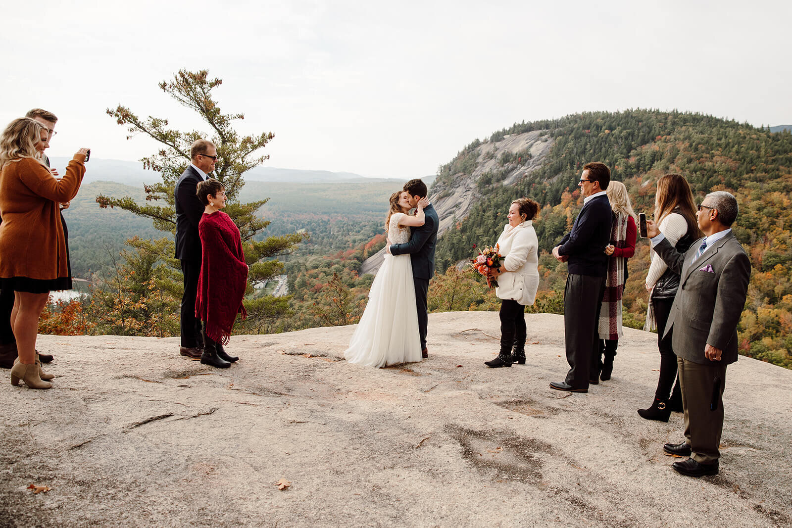  Bride and groom kiss during their ceremony during elopement in the White Mountains in New Hampshire. New Hampshire elopement packages. 