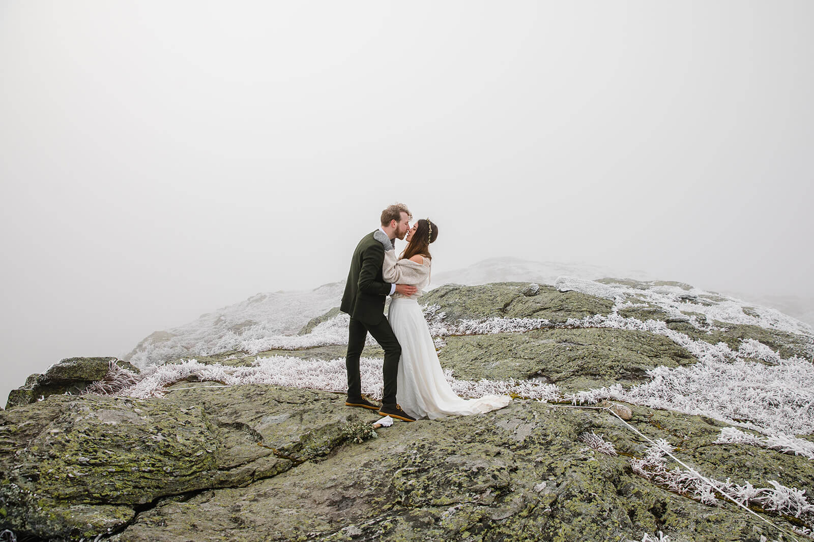  Eloping couple exchanges kiss in frosty conditions during their adventure elopement on Mt. Mansfield, Vermont’s tallest mountain.  Vermont mountain wedding. Vermont winter elopement. Vermont elopement packages. 
