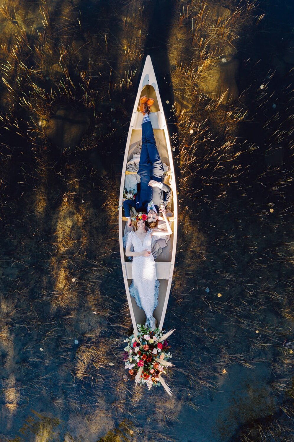  Couple elopes in the Adirondacks in Upstate New York and canoes on a beautiful lake. Upstate NY elopement photographer. Adirondack adventure elopement. 