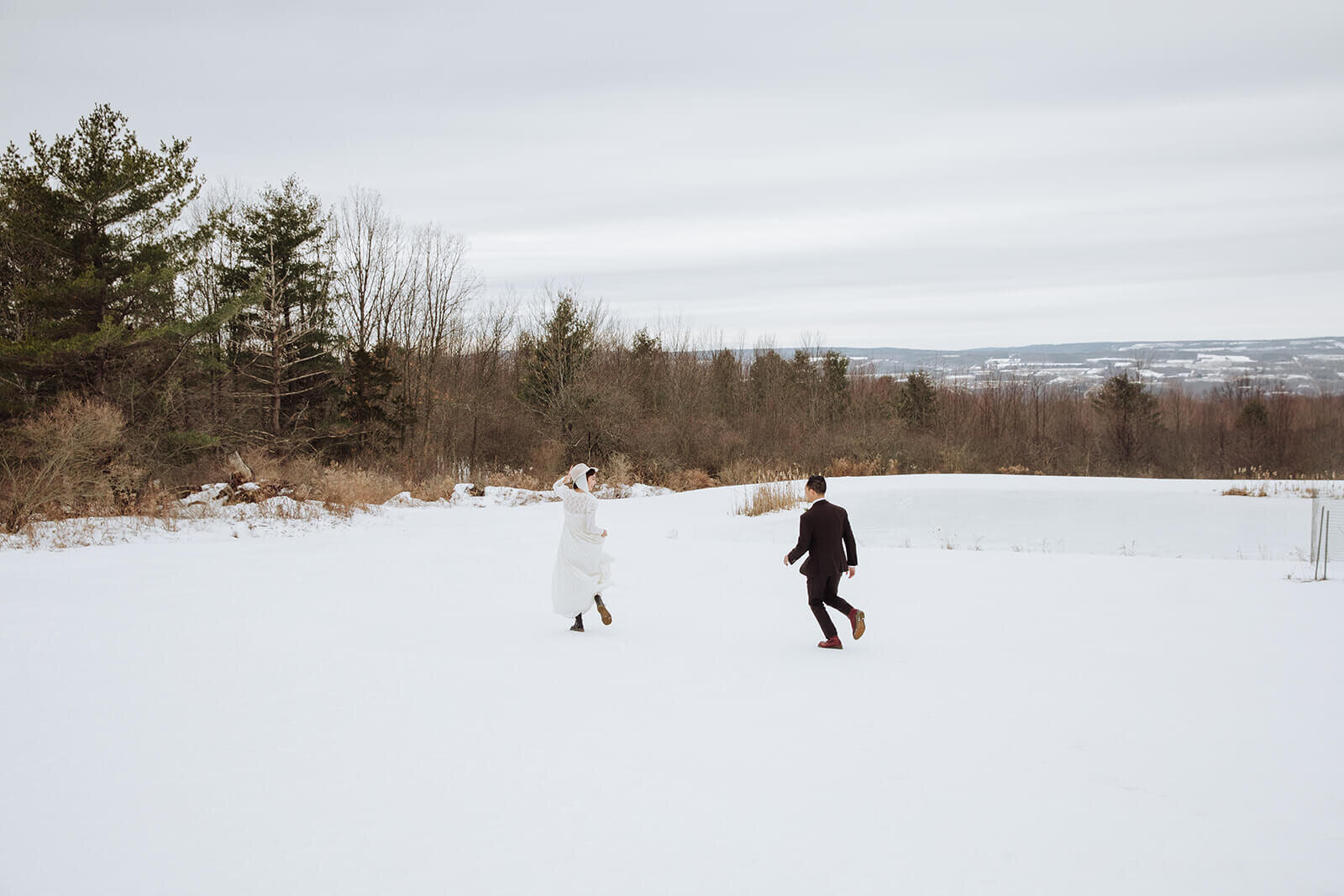  Stylish NYC couple elope late winter in the Finger Lakes region of Upstate NY. Couple plays in the snow 