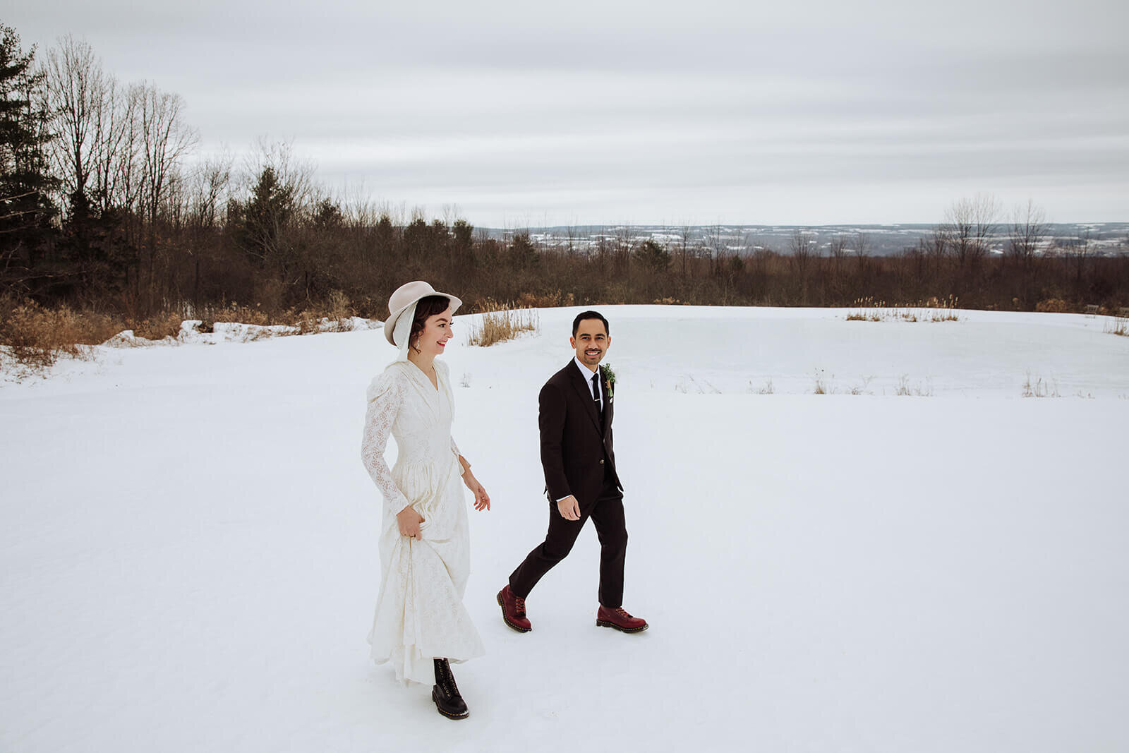  Stylish NYC couple elope late winter in the Finger Lakes region of Upstate NY.  Couple walks through the snow 