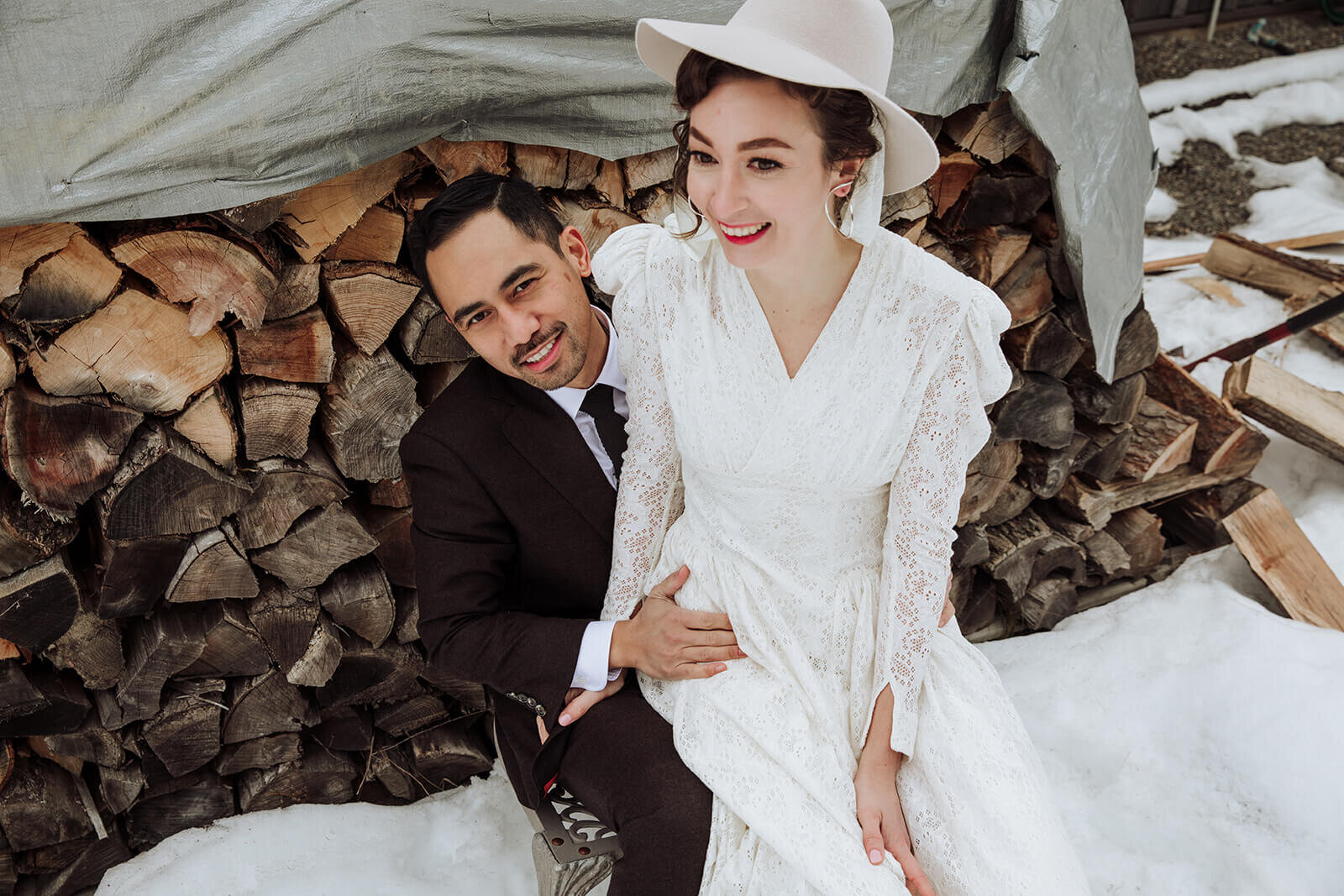  Stylish NYC couple elope late winter in the Finger Lakes region of Upstate NY. Couple plays by wood pile 
