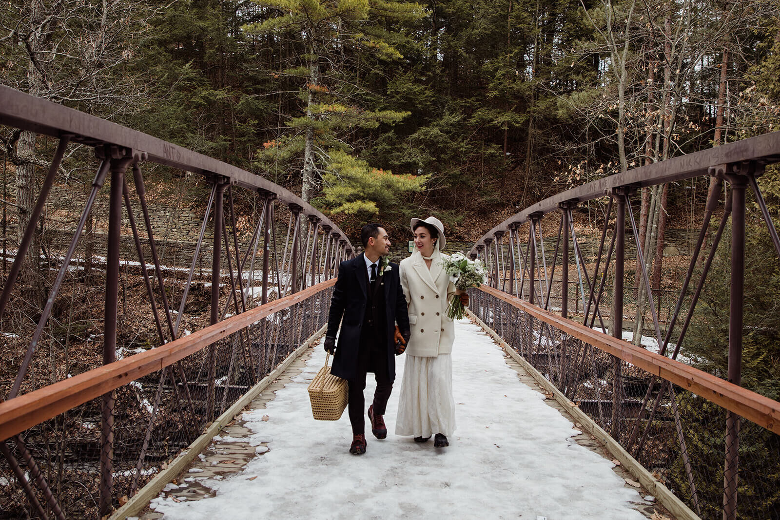  Stylish NYC couple elope late winter in the Finger Lakes region of Upstate NY. Couple hikes to ceremony spot over a bridge 