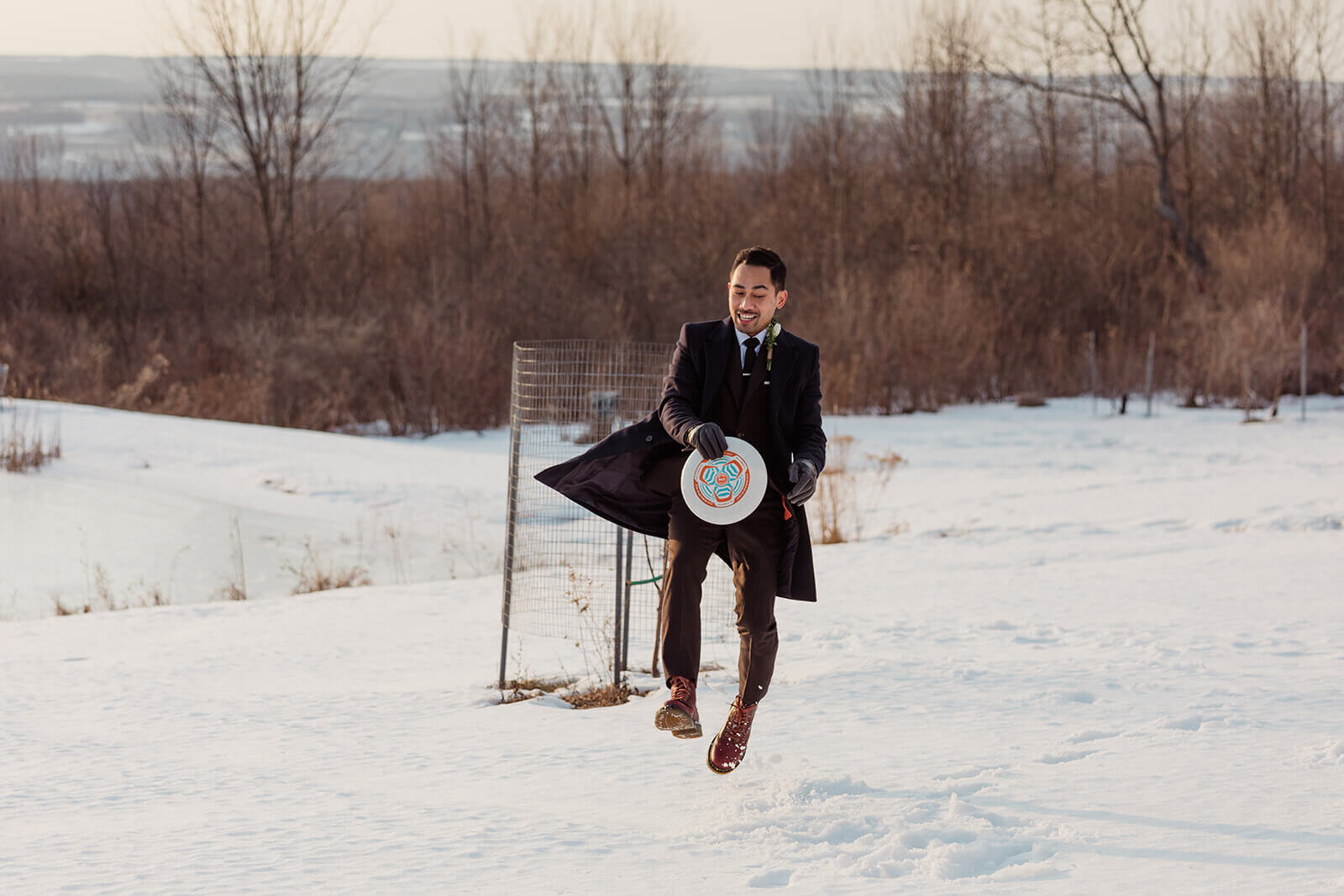  Stylish NYC couple elope late winter in the Finger Lakes region of Upstate NY.  Playing frisbee 