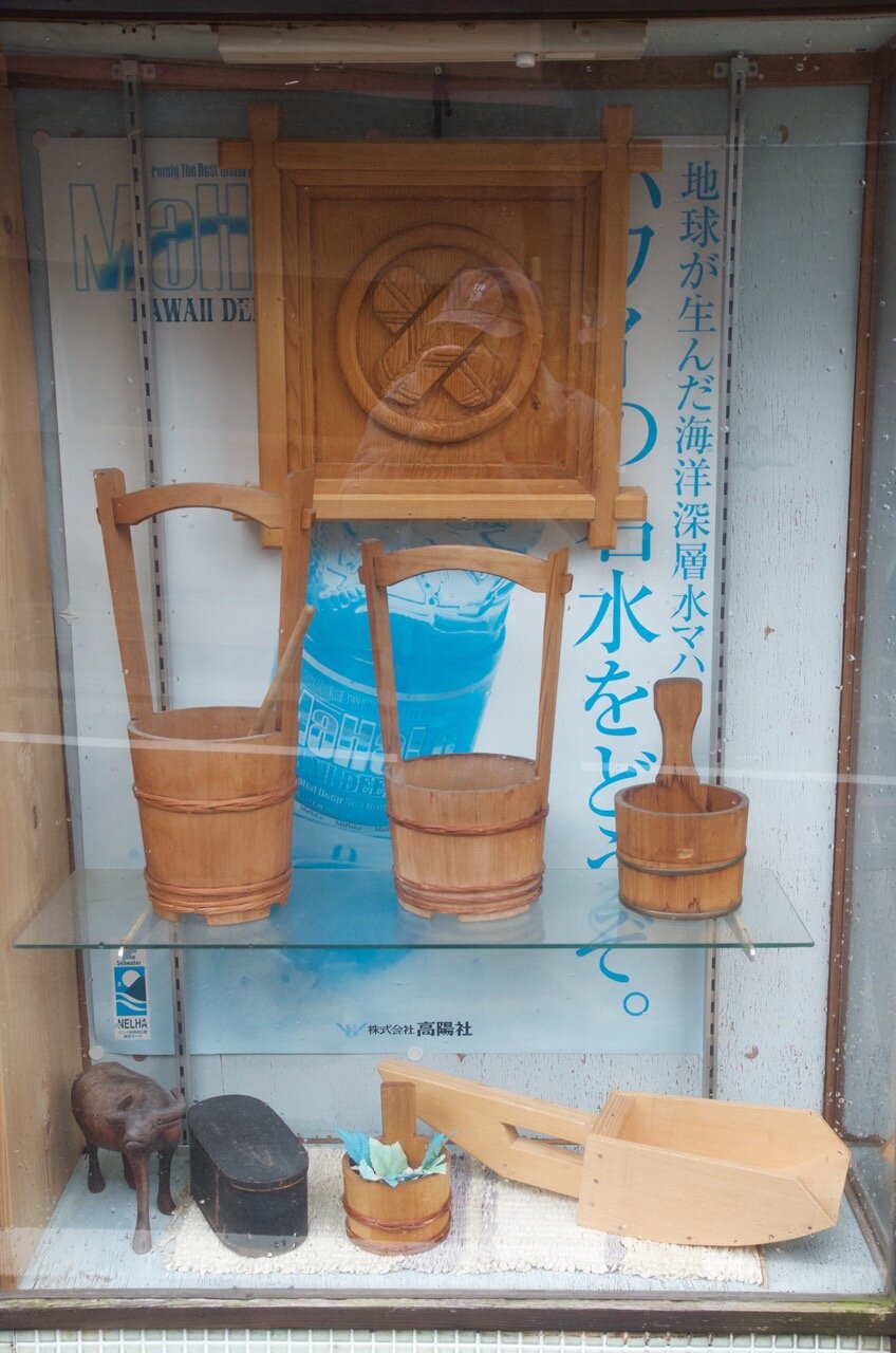  The display case out of the bathtub craftsman’s workshop containing his buckets, as well as a boat bailer. Photo Credit: Douglas Brooks. 