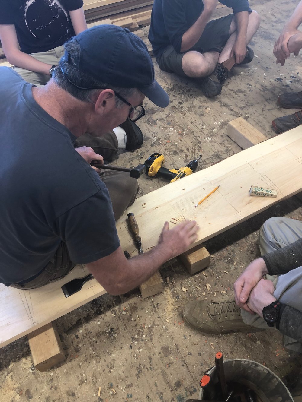  Once the planks are fit, they get edge-nailed together. Holes are chiseled into both planks and mortises are cut into one of the sides of the planks to receive the nail heads. Here you can see Douglas laying out the mortises to be chiseled. 