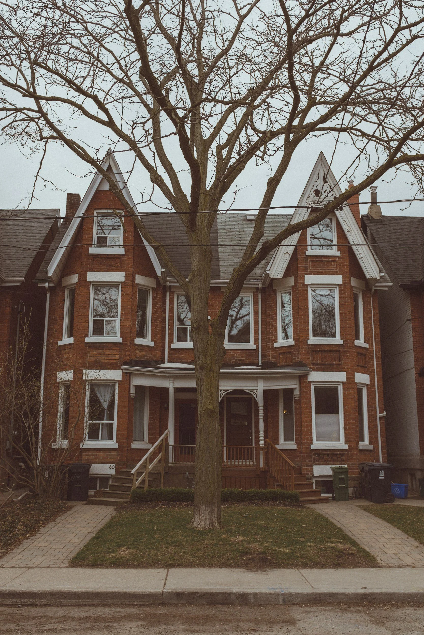 Row of Victorian brick houses on a tree-lined Toronto street