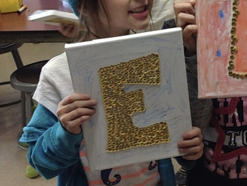 Proud student with their thumbtack art