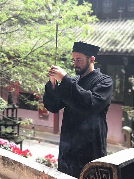 Shifu Sweeney making incense offering at monastery temple, Sichuan China