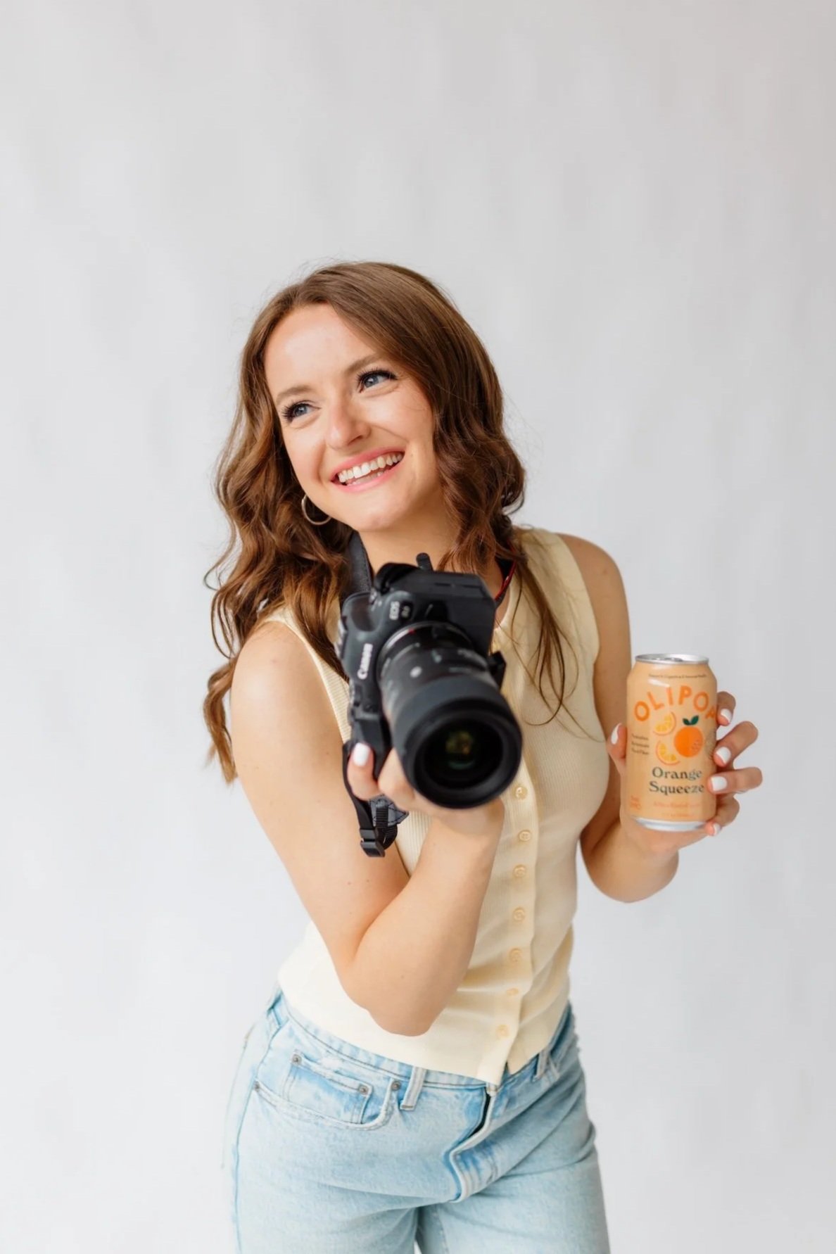 Minneapolis brand photographer with camera and orange drink