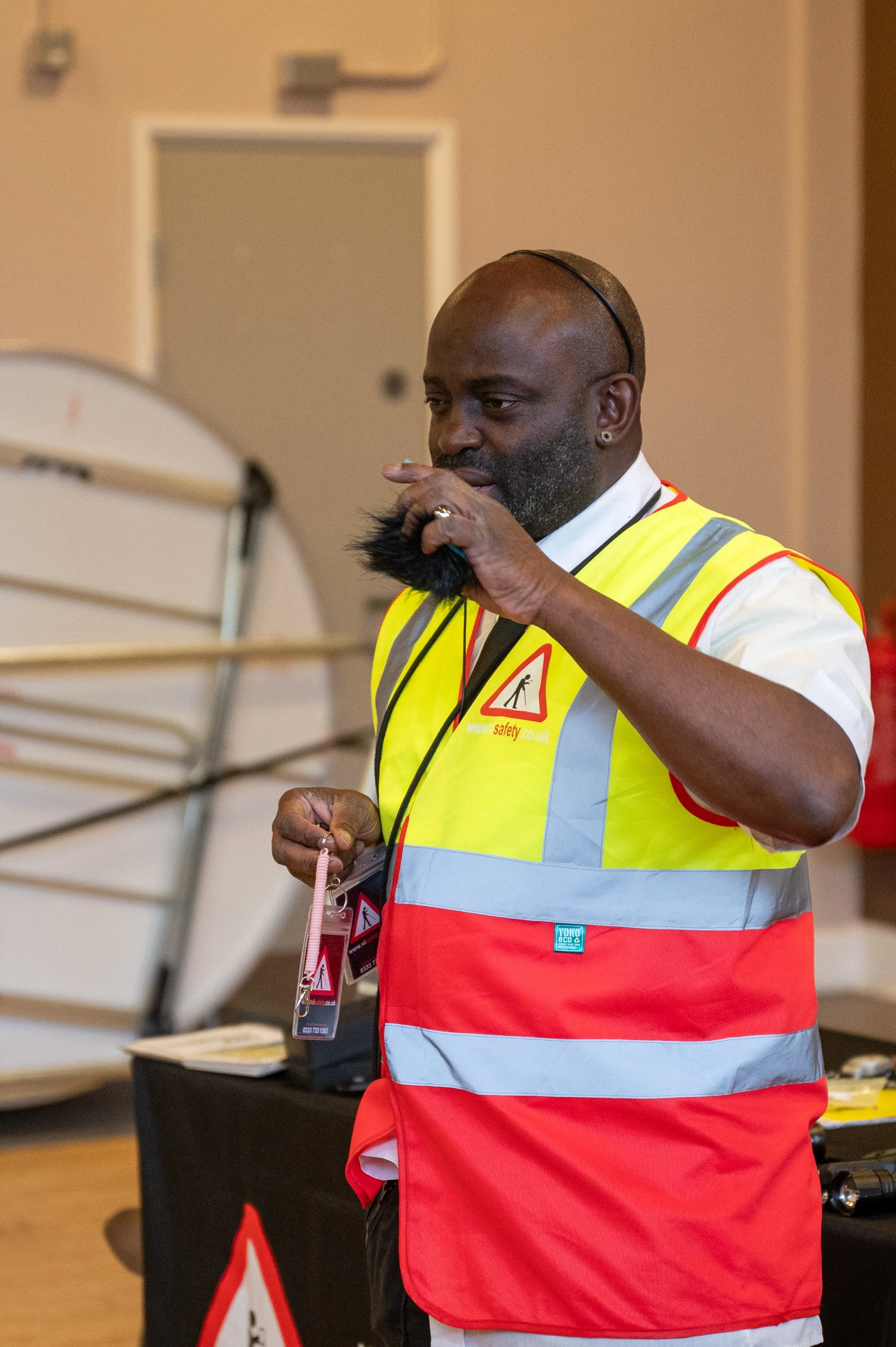  Andrew Palmer, with his VISafety yellow jacket, presenting to people through a speaker  