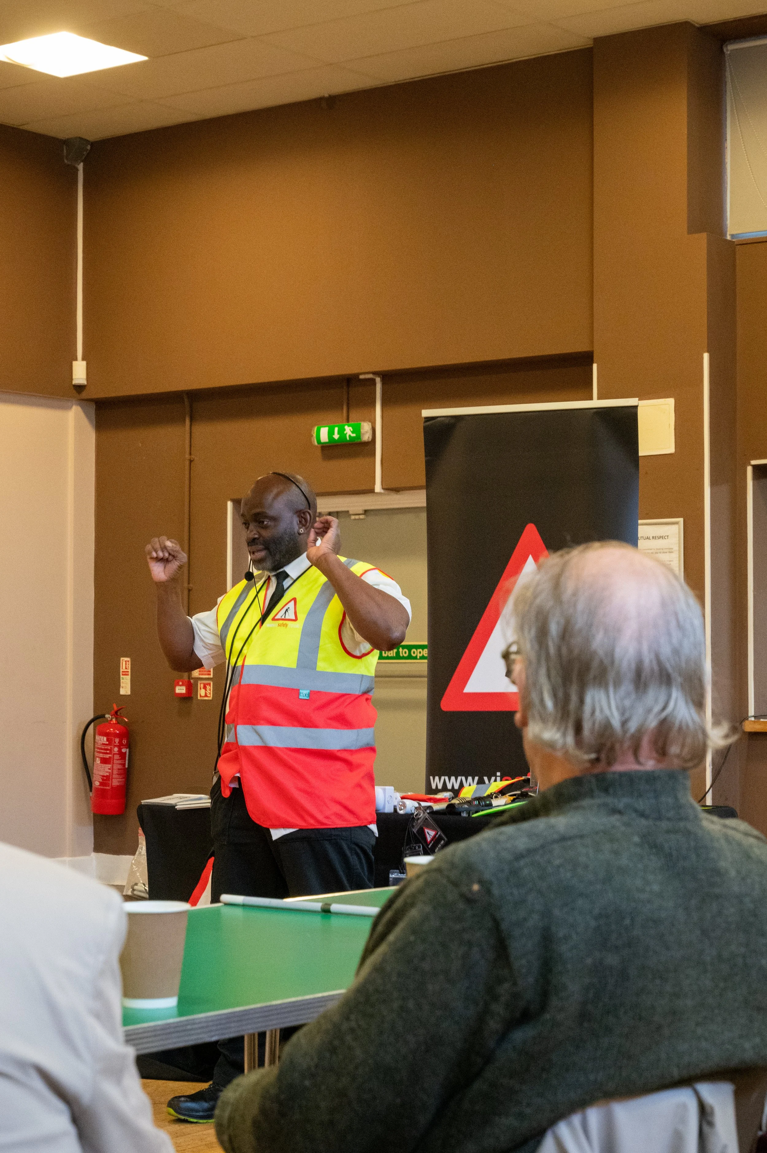  An image showing Andrew Palmer speaking to a crowd with his hands in the air. 