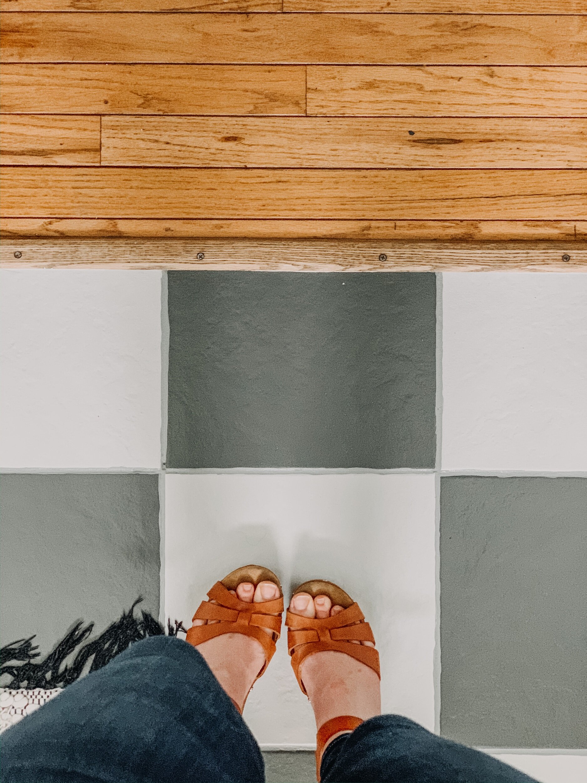 this is a photo of a pair of feet on a painted tile floor