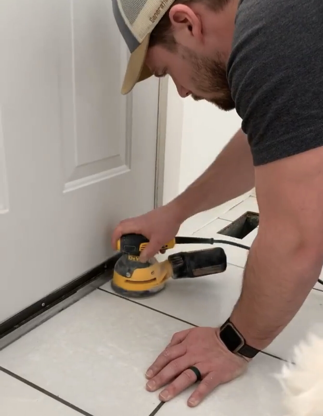 this is a photo of a man sanding tile floors to prep them