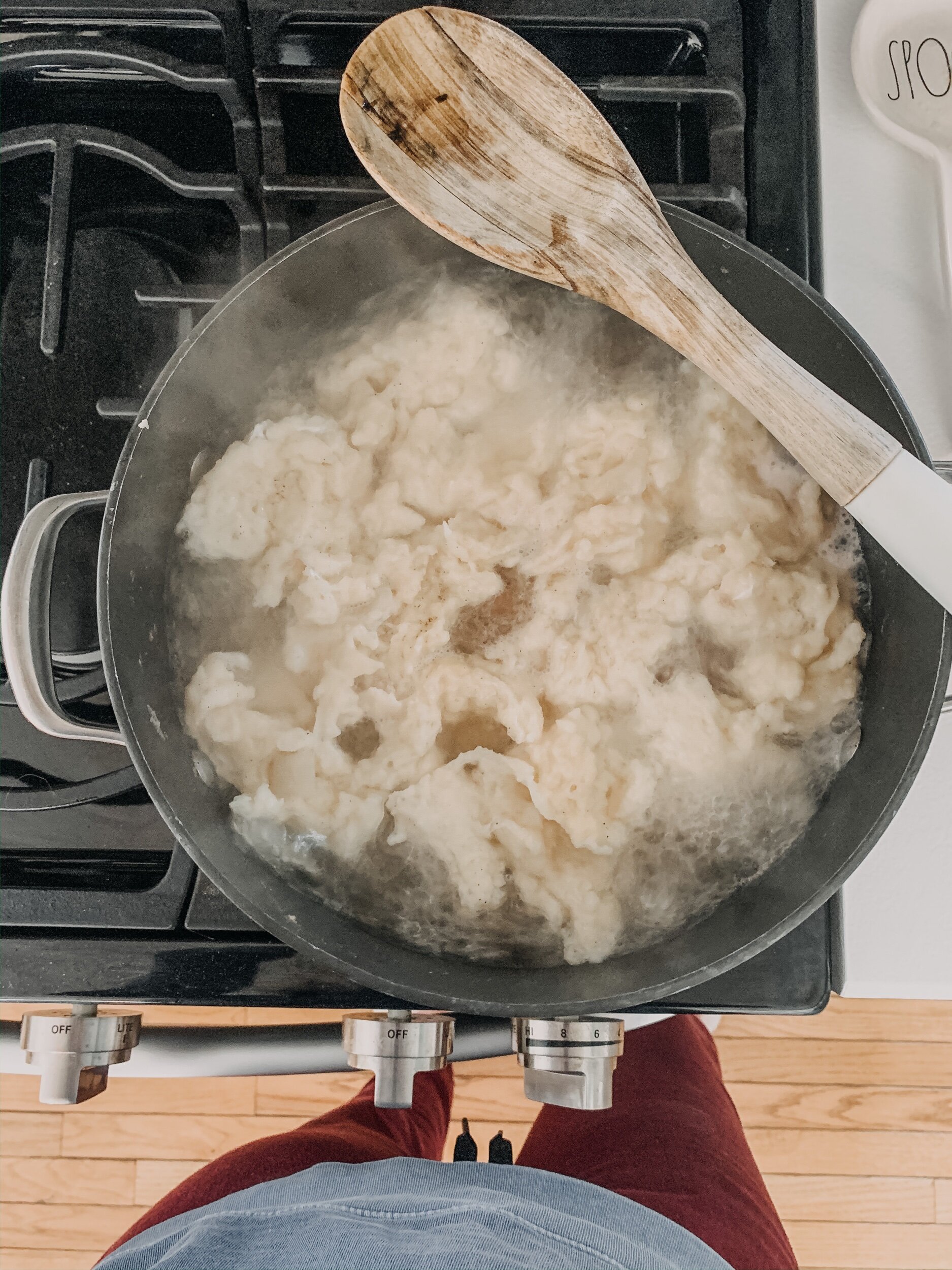 this is a photo of a pot on a stove full of mennonite farmer sausage soup with dumplings on top