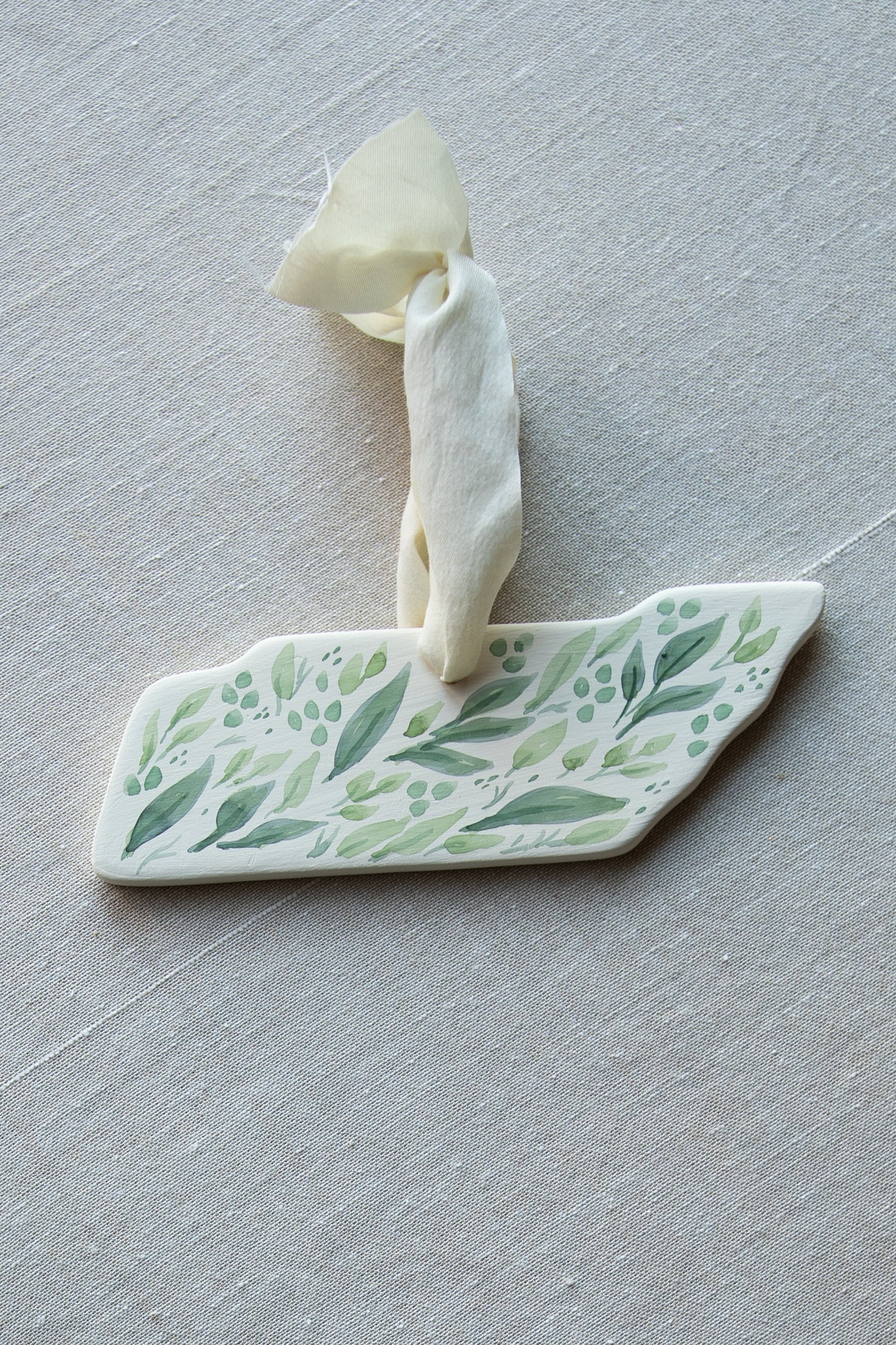 Ellywise Studios, local Memphis TN artist. Hand painted watercolor Christmas ornament Tennessee state TN Holiday 2021. Watercolor greenery, cream silk ribbon