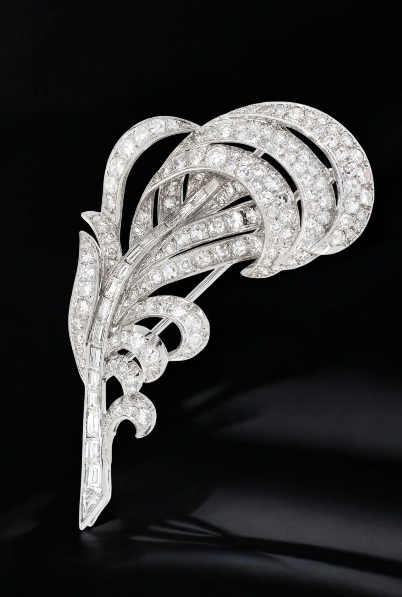 MID CENTURY PLATINUM AND DIAMOND FEATHER BROOCH Modelled as a plumed feather, the centre channel-set with baguette-cut diamonds, the surround pavé-set throughout with single-cut diamonds, the diamonds together weighing approximately 3.00 carats