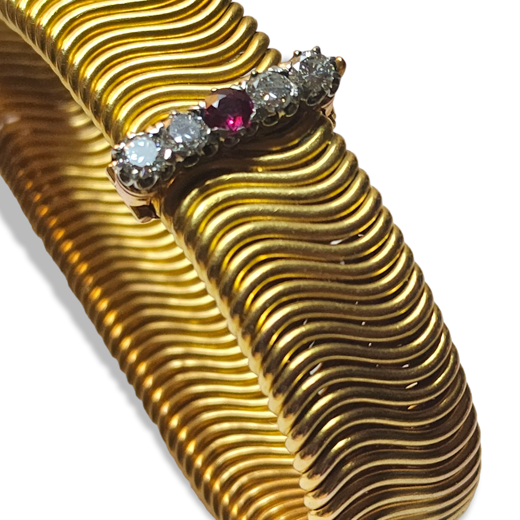 MID CENTURY FLEXIBLE GOLD BRACELET Highly articulated double wire work,the clasp set with a round ruby 0.29 cts and 4 round diamonds 0.75 cts. 49.3 grams, French, makers marks