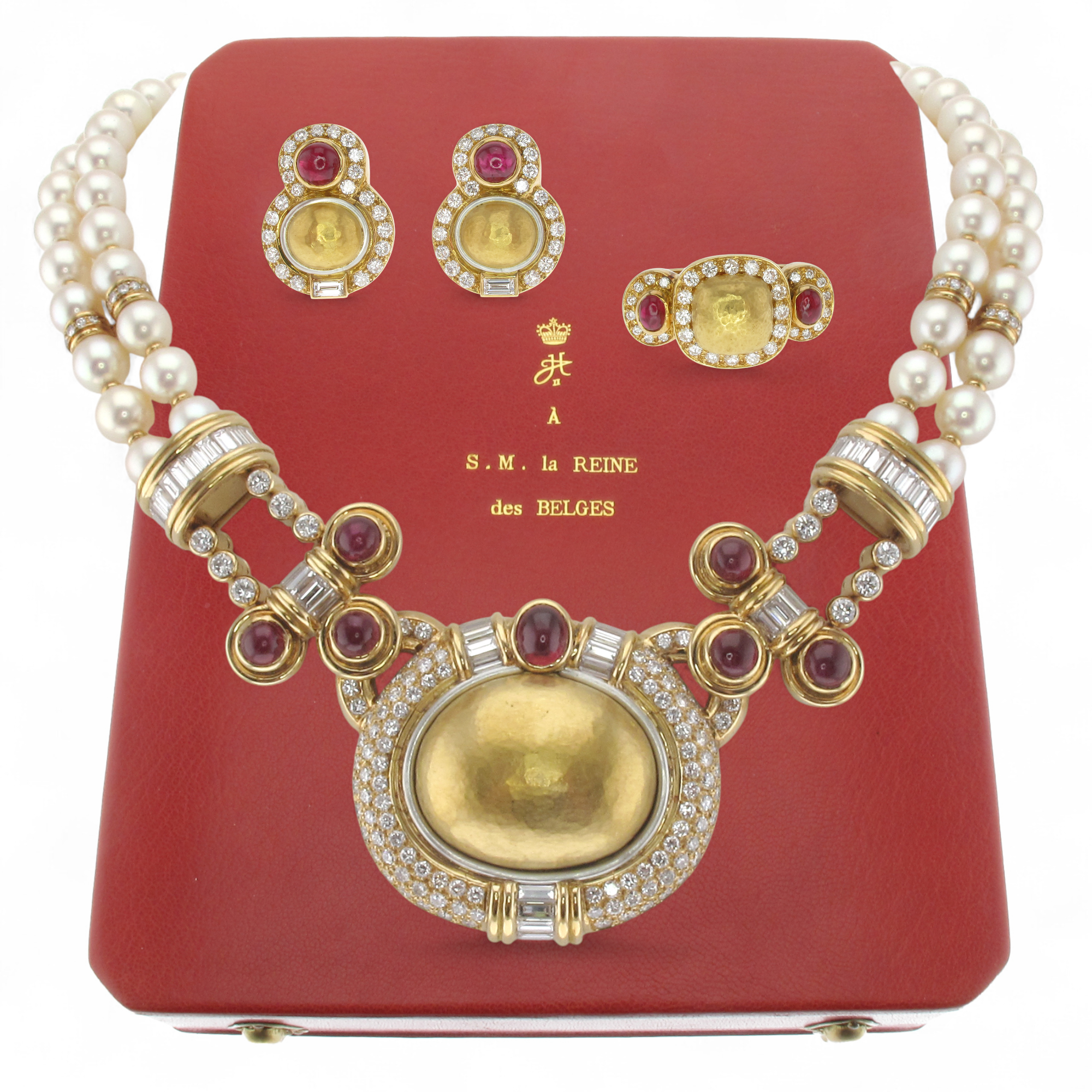  1980s RUBIES And CULTURED PEARL SET by CHAUMET with royal provenance.
 
Comprising a necklace with a V-shaped front composed of an oval pendant, centering a hammered gold dome in a diamond pav surround, with channel-set baguette-cut diamonds and cab
