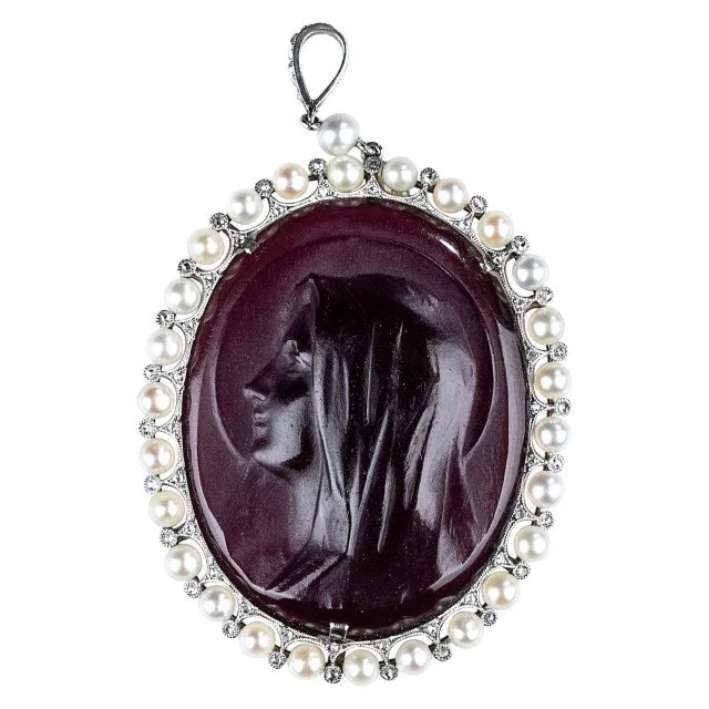 Belle Epoque Ghiso Platinum, Pearl, Diamond and Glass Cameo Pendant
One oval purple glass cameo ap. 30.0 x 23.0 mm., 27 pearls, small rose-cut diamonds, signed Ghiso, c. 1910.