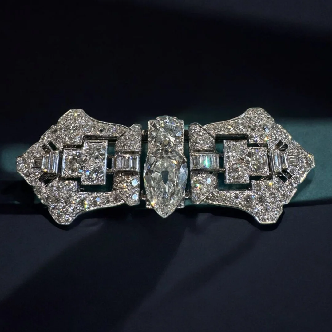 ART DECO PLATINUM, GOLD, DIAMOND DOUBLE CLIP BROOCH. The pair of geometrical designed platinum and diamond clips is set with approximately 7.5 cts of round and square cut diamonds. The clips include a frame in 18kt white gold that centers two larger