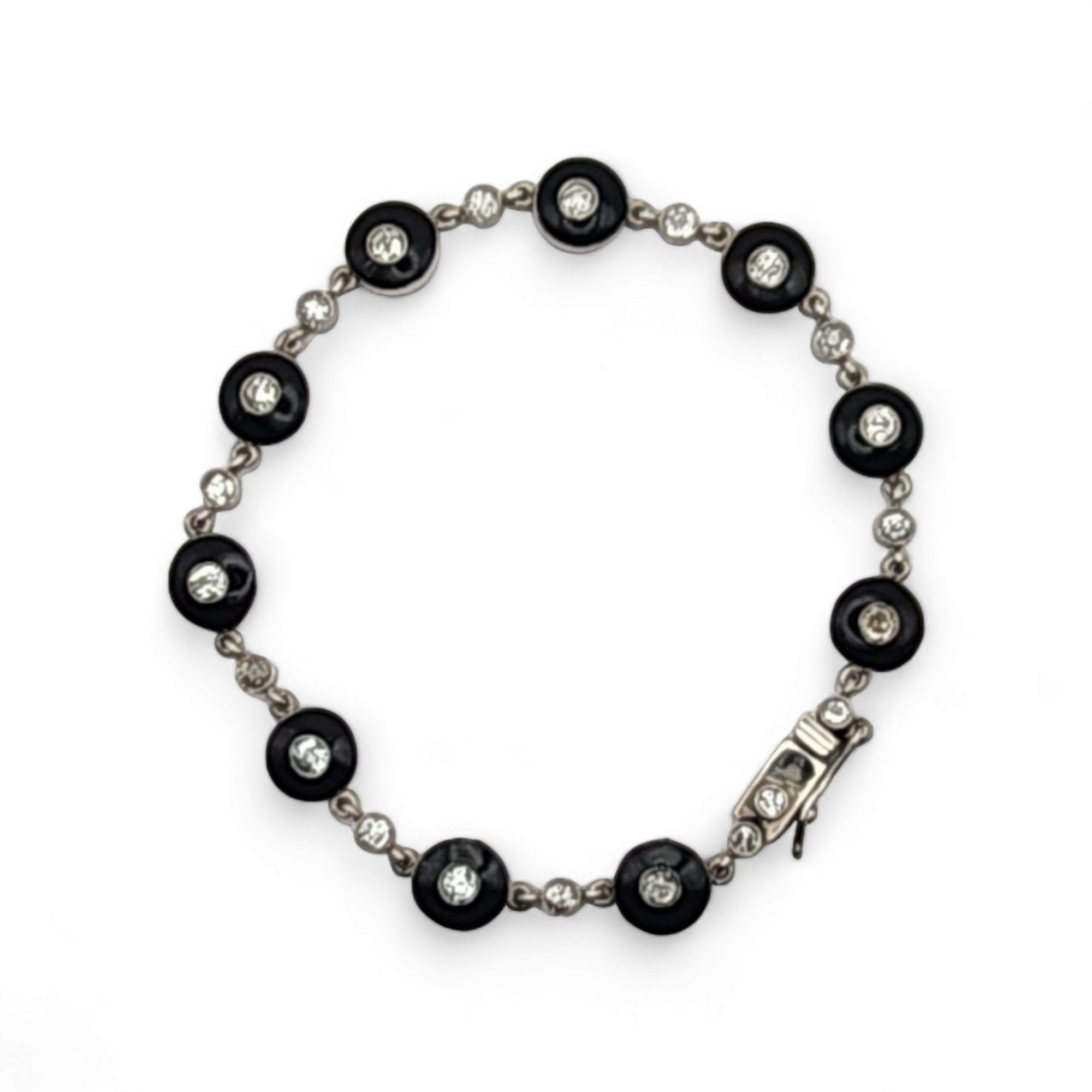 ART DECO PLATINUM, DIAMOND AND ENAMEL LINE BRACELET A line bracelet comprising ten round disks centering round diamonds surrounded by black enamel and connected by ten round diamonds set in bezels. Total diamond weight circa 2.1 cts, length 18.5 cm