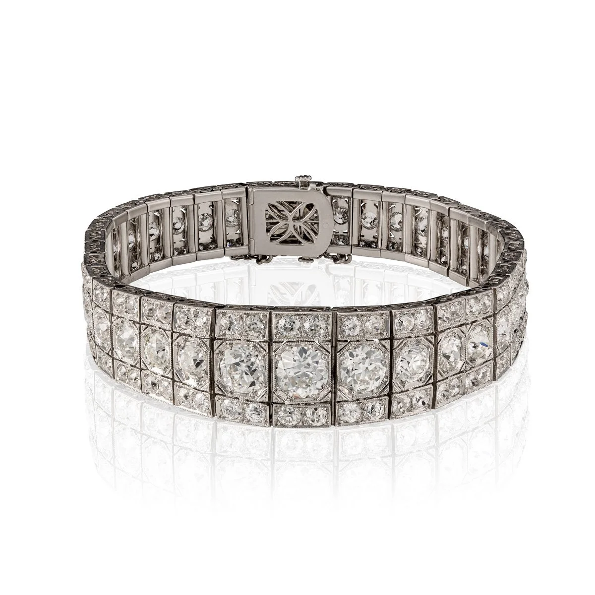 ART DECO PLATINUM DIAMOND BRACELET
Designed as a tapered band of old European-cut diamonds weighing approximately 18 carats centering
on a 1.3ct center diamond accented with geometric millegrain settings, circa 1925; length 18.5cm