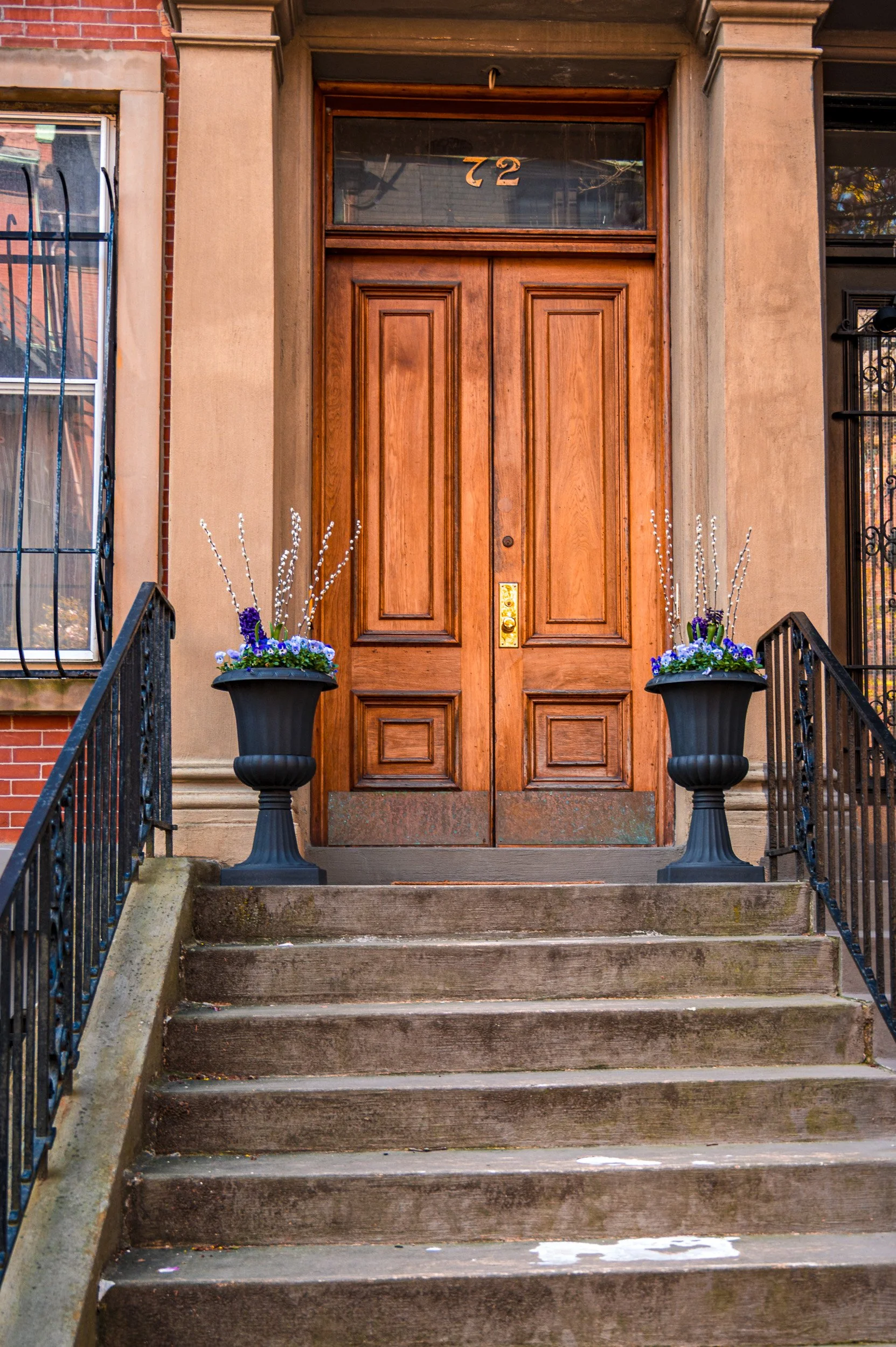 The door at #72 in Back Bay, Boston, flanked by pussy willow, pansy, and hyacinth urns in spring 
