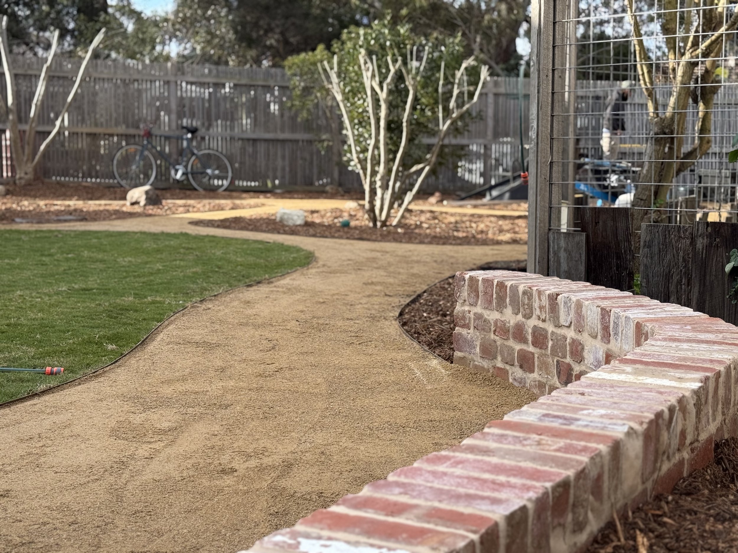 Retaining wall along pathway with toppings, and fruit trees