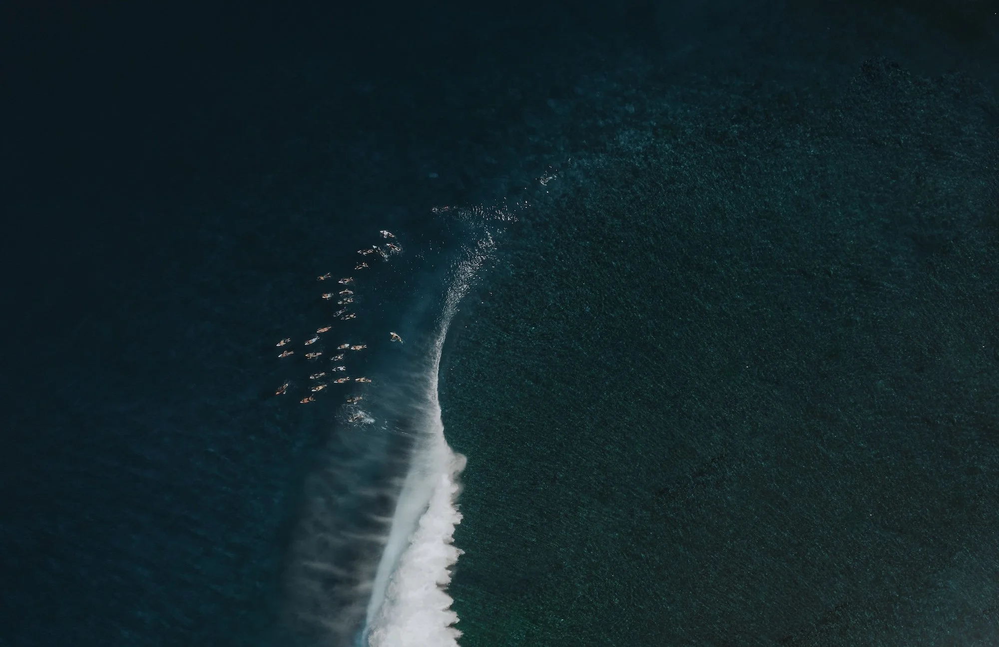 Aerial view of a group of boats creating a wake as they travel through the ocean.