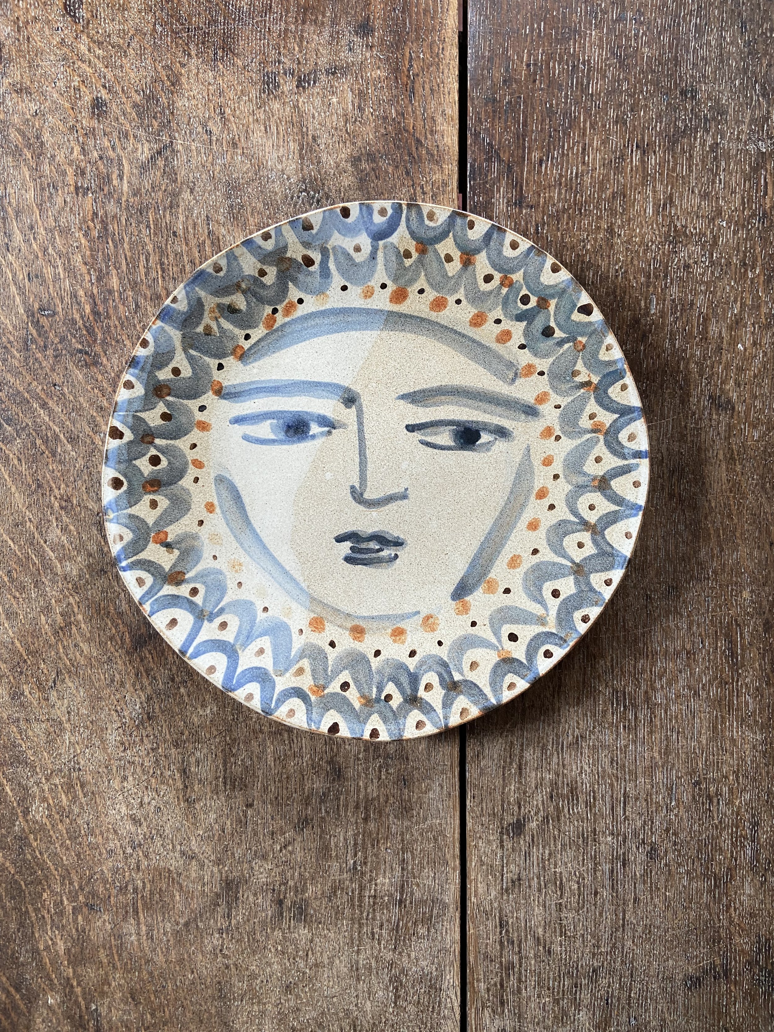handmade circular plate with face design by Charlotte Salt