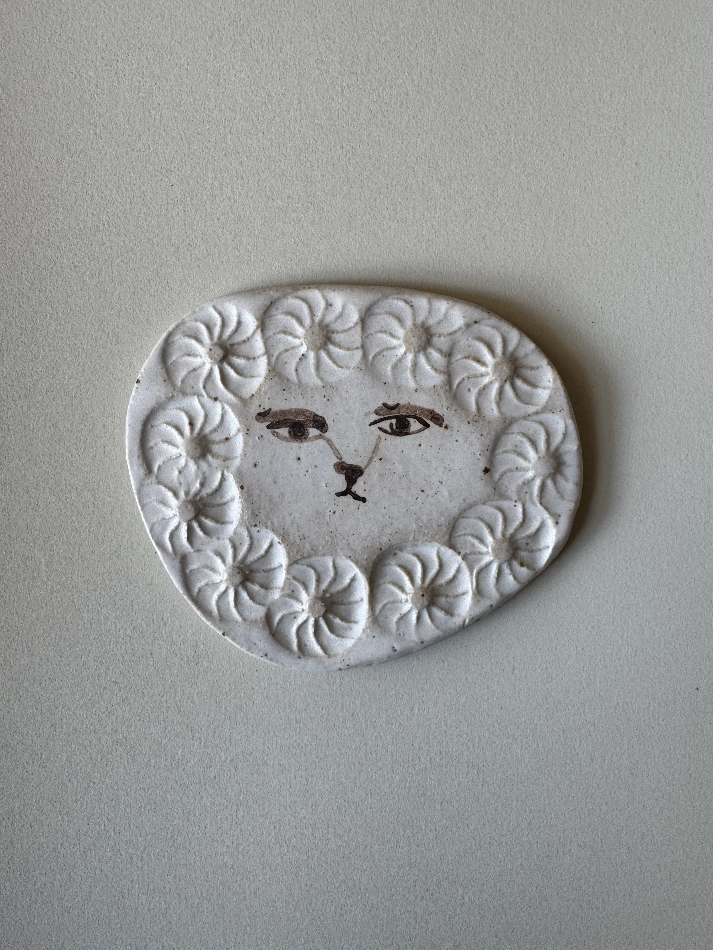 Ceramic face tile by Charlotte Salt