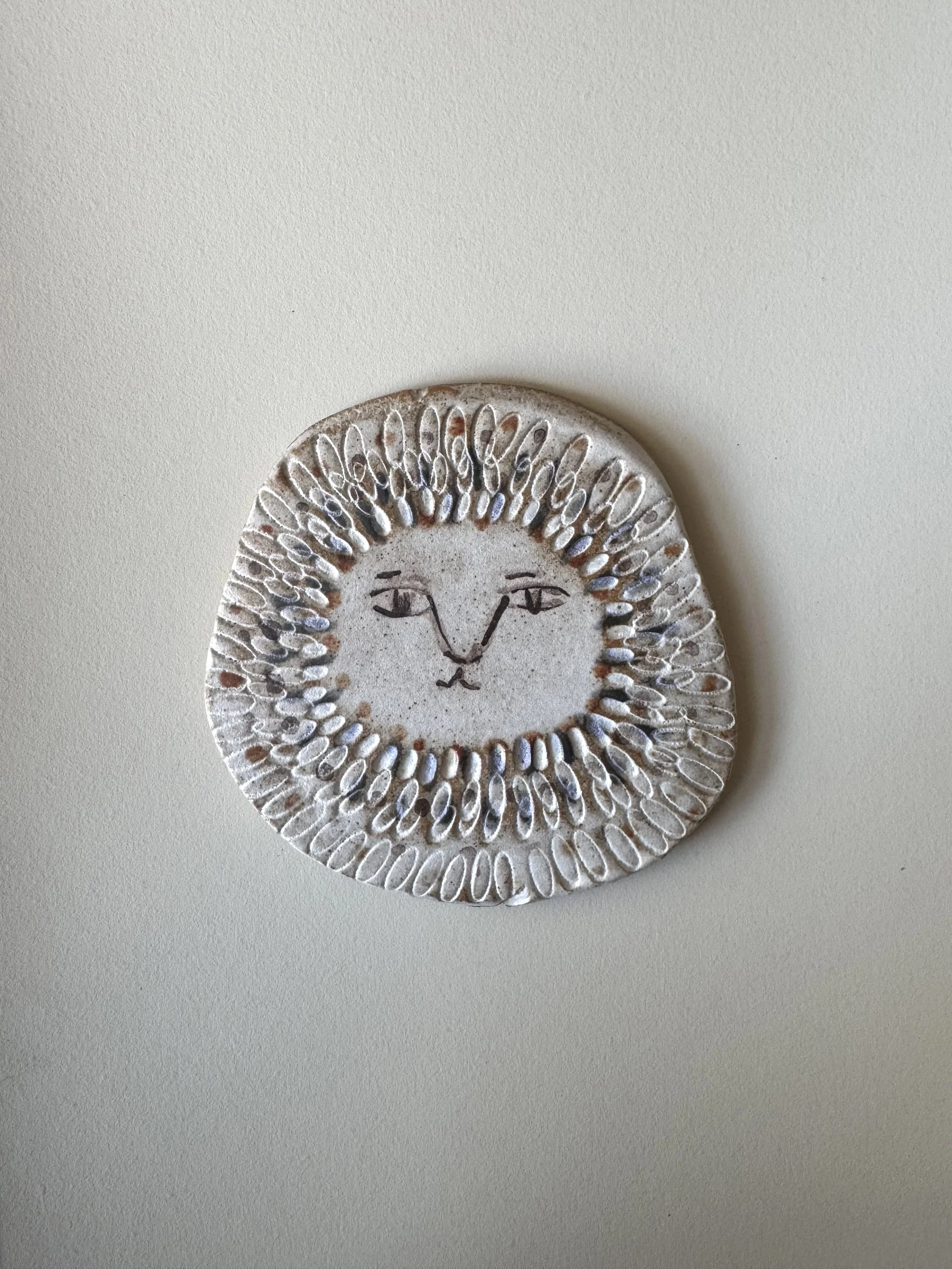 Ceramic face tile by Charlotte Salt