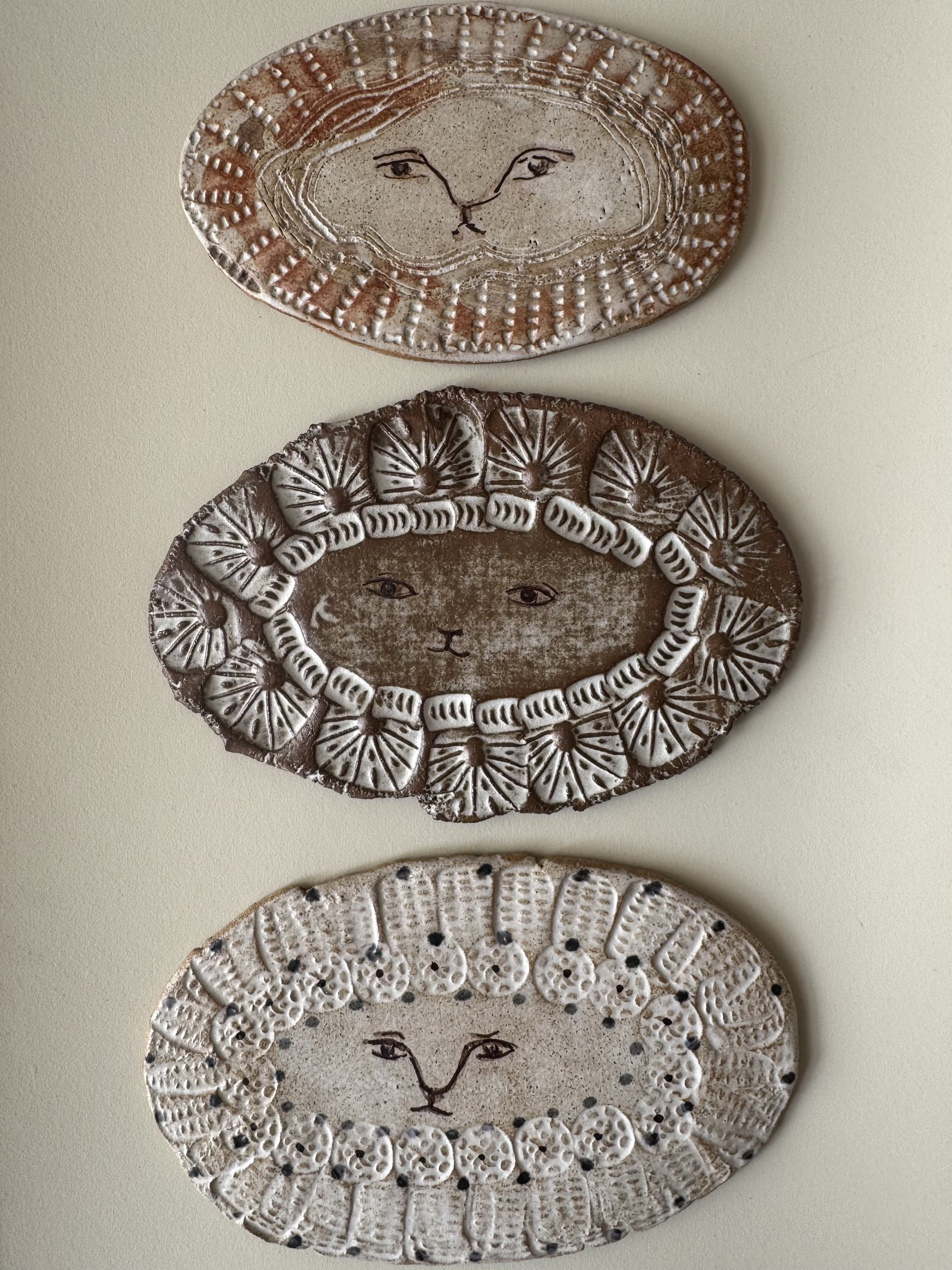 Handmade ceramic lion face tiles by Charlotte Salt