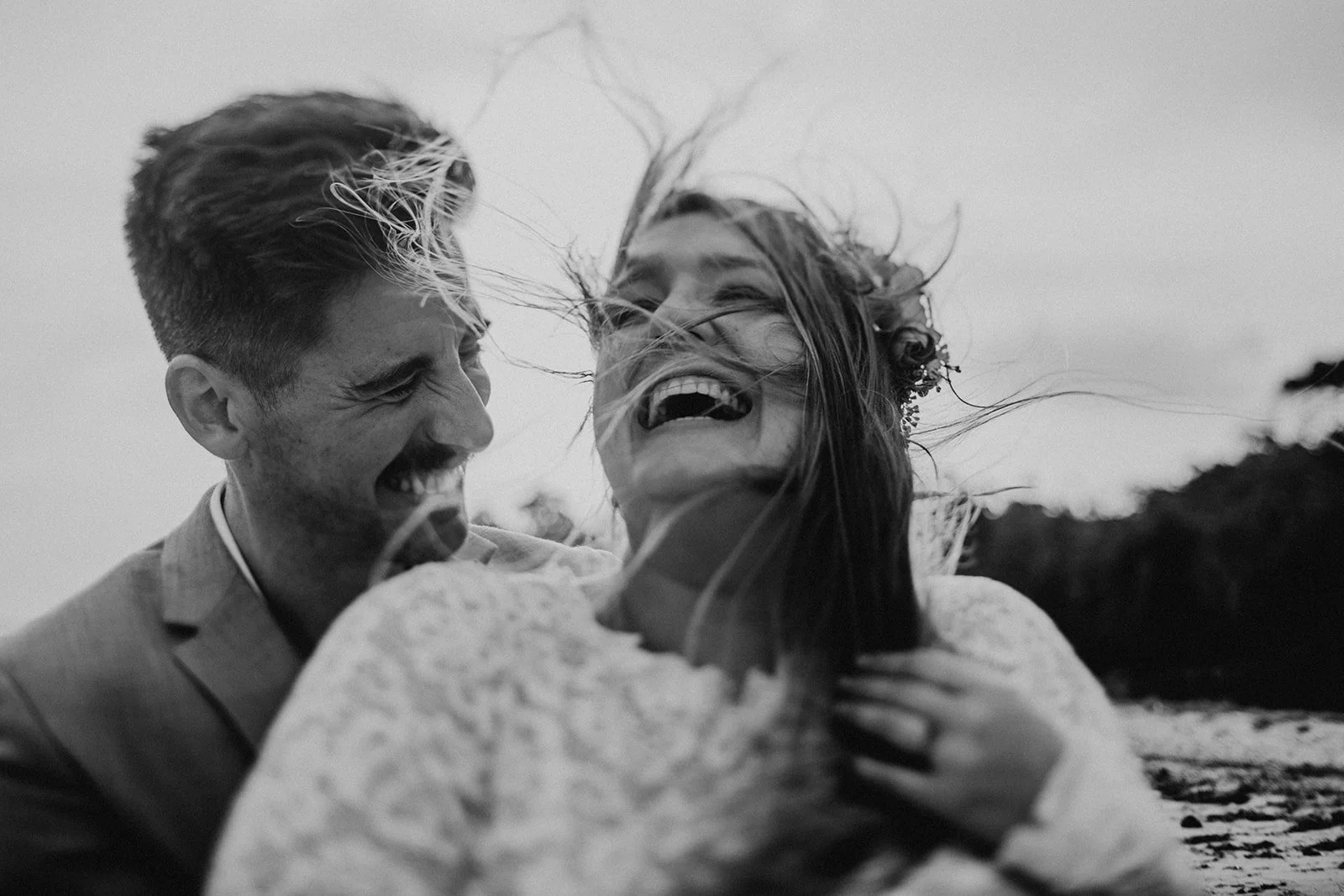 A laughing couple during their beach wedding portraits