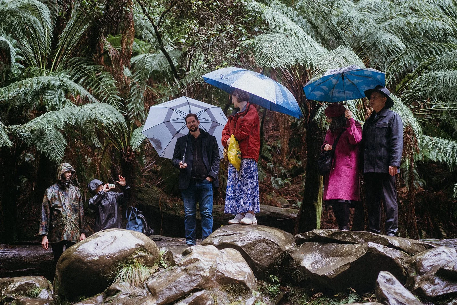 Guests holding umbrellas during an Otways waterfall elopement