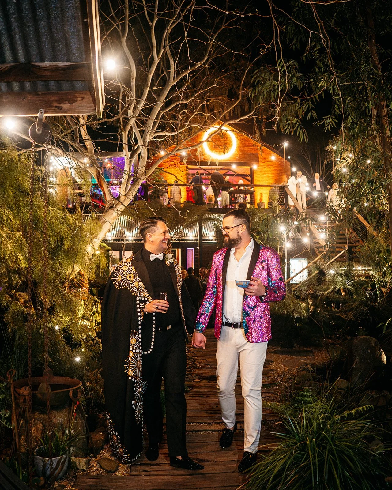 Two grooms walking hand in hand for some portraits during their wedding