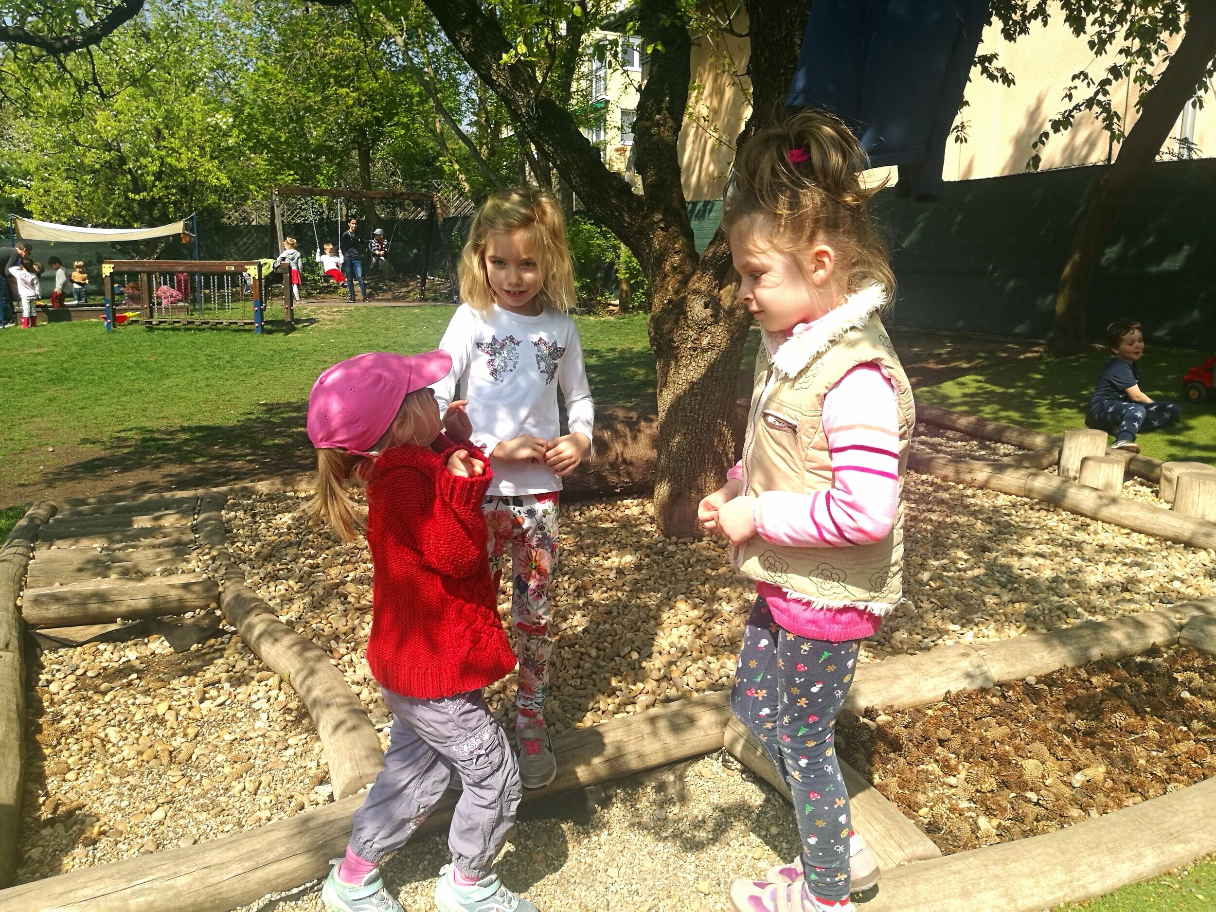 Girls role-playing in the garden.